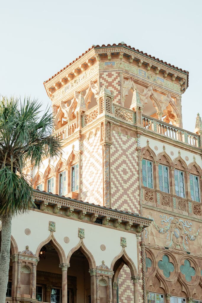 The Ringling Engagement Photos | Jennifer Holly Light and Airy Wedding Photographer in Orlando | Historic mansion with intricate Moorish design features ornate arches, detailed tile patterns, and lush palm trees, exuding elegance and grandeur.