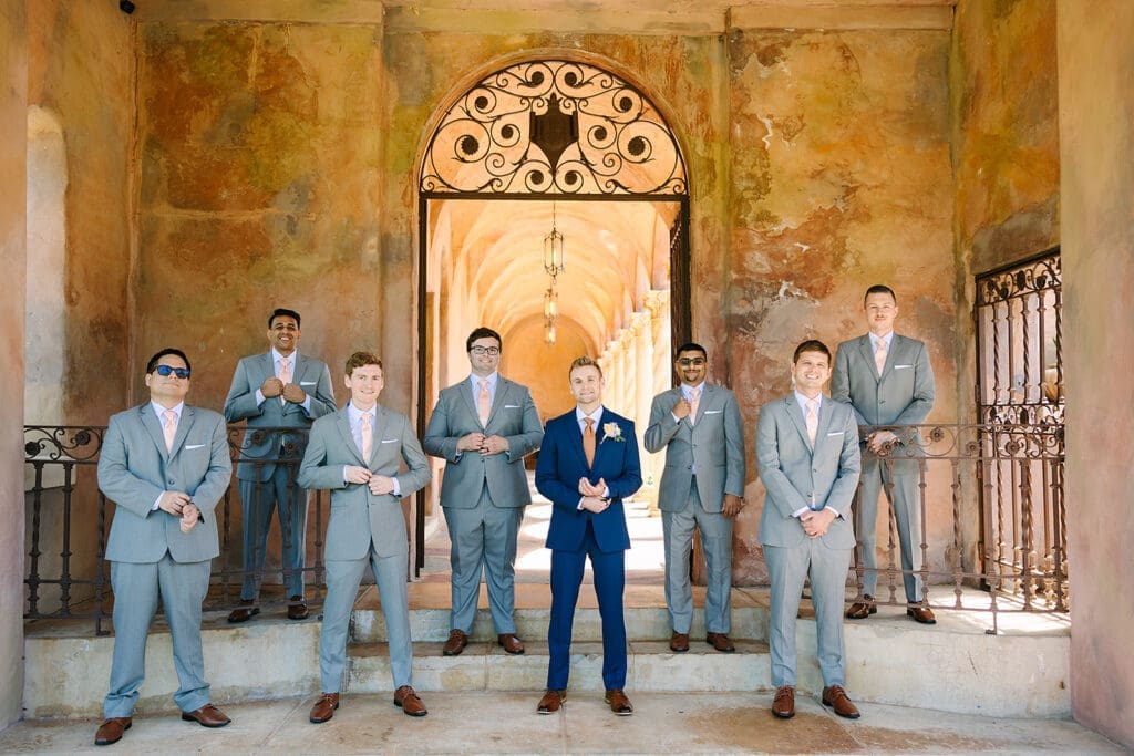 groom in a blue suit with groomsmen in gray suits at The Howey Mansion captured by Jennifer Holly Photography