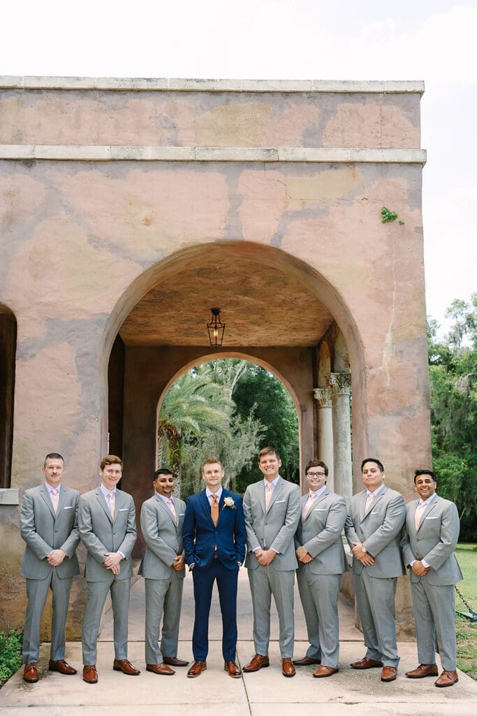 groom in a blue suit with groomsmen in gray suits at The Howey Mansion captured by Jennifer Holly Photography