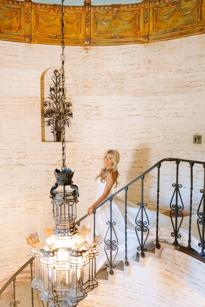 Bride walking down a curved staircase at The Howey Mansion captured by Jennifer Holly Photography