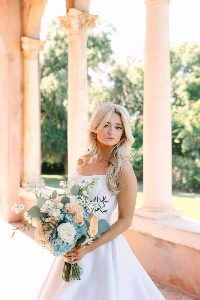 bride portrait under stone archway holding bouquet at The Howey Mansion captured by Jennifer Holly Photography