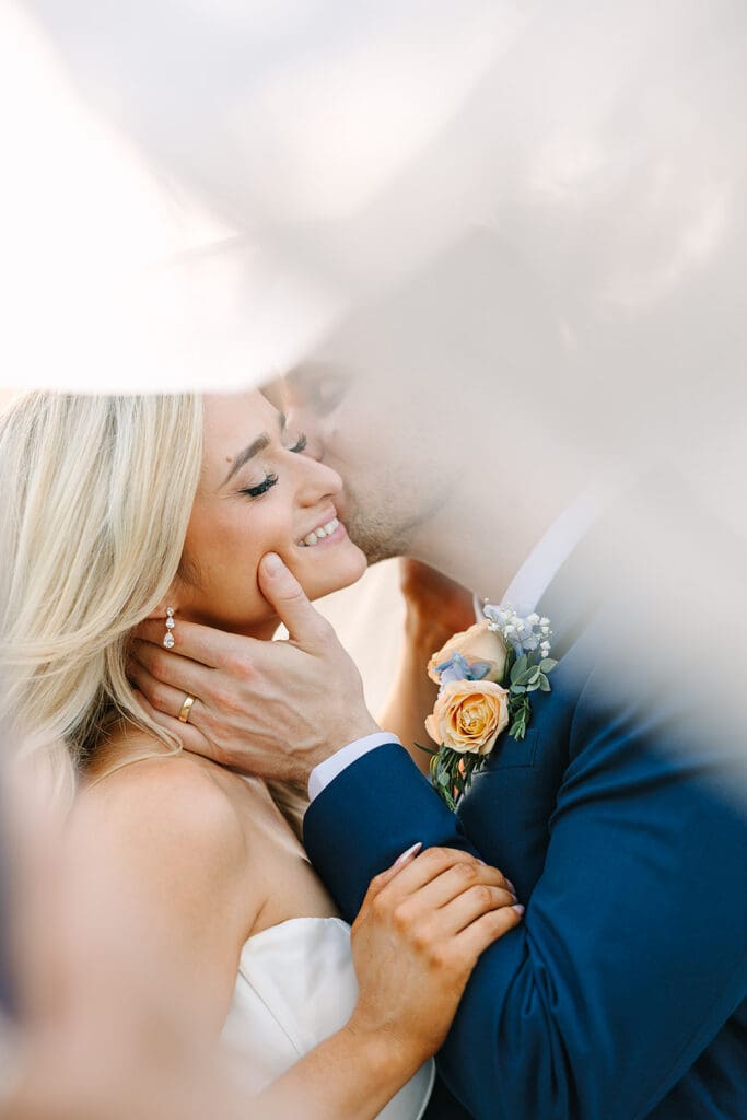 bride and groom outdoor wedding portrait under her veil at The Howey Mansion captured by Jennifer Holly Photography