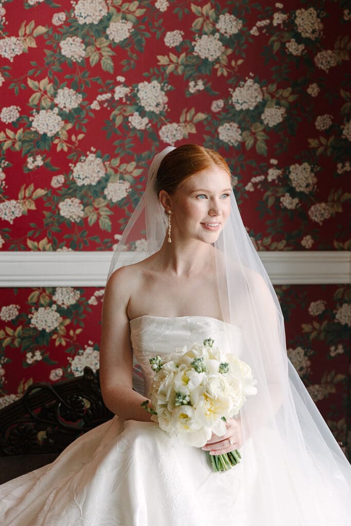 bride portrait in front of red floral wallpaper at Florida mansion wedding venue, Luxmore Grande Estate, captured by Jennifer Holly Photography
