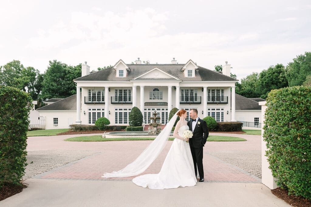 bride and groom portrait in front of their Florida mansion wedding venue, Luxmore Grande Estate, captured by Jennifer Holly Photography