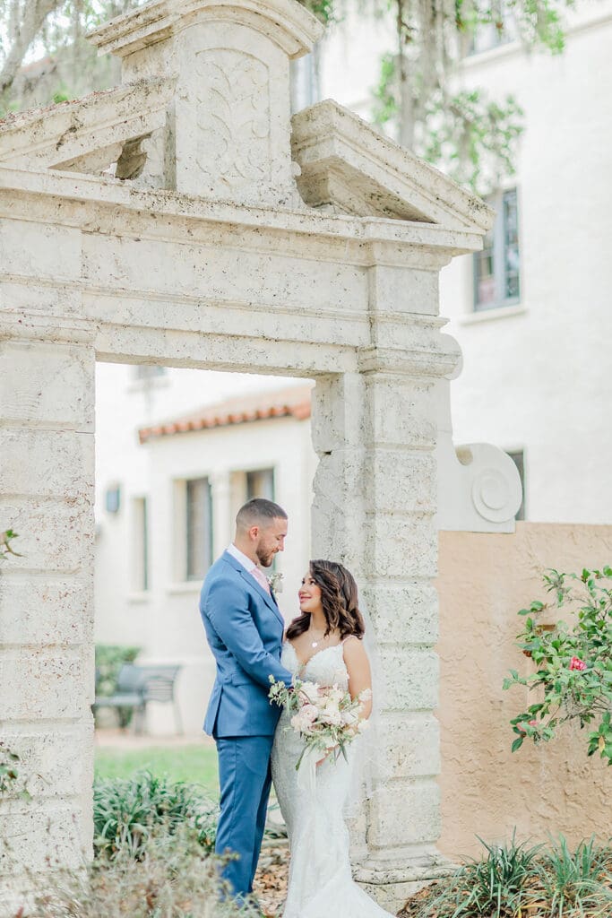 bride and groom under a stone archway at Rollins College, captured by Florida elopement photographer Jennifer Holly Photography