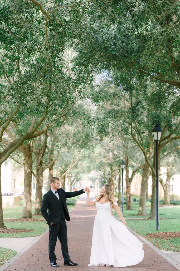 bride and groom dancing on a tree-lined street at Rollins College, captured by Florida elopement photographer Jennifer Holly Photography