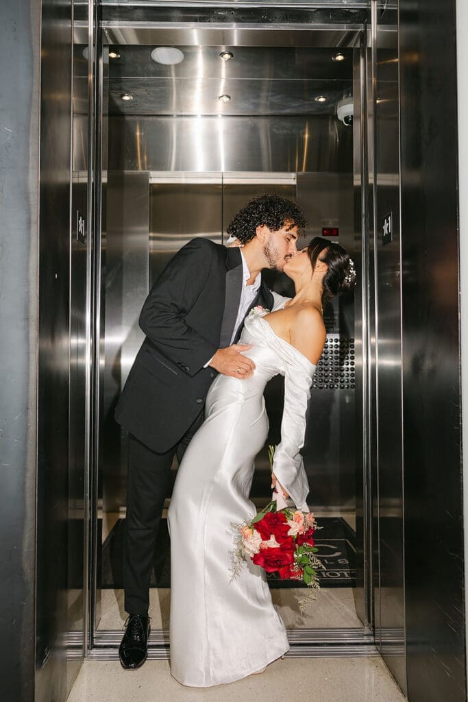 bride and groom kiss in an elevator in downtown Orlando in an elopement portrait captured by Jennifer Holly Photography, an Orlando elopement and wedding photographer