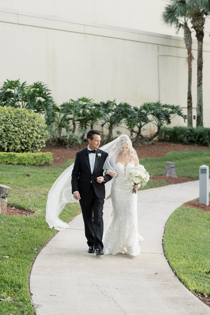 bride and her father walk into an outdoor wedding ceremony at Hyatt Regency Grand Cypress Resort in Orlando, Florida, captured by Jennifer Holly Photography