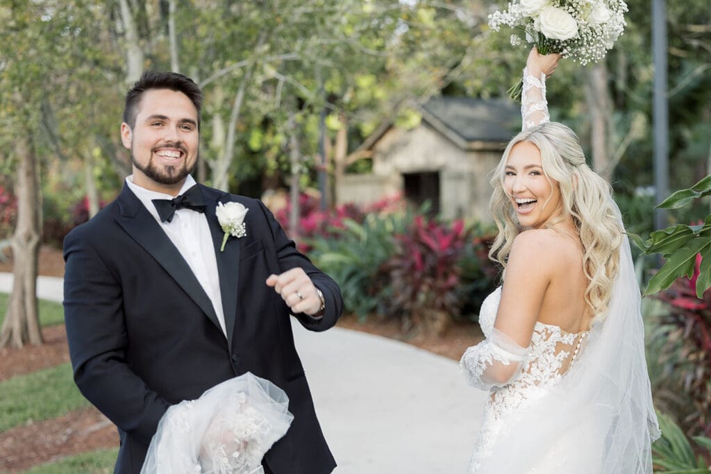 bride and groom candidly smile on a path outside their wedding at Hyatt Regency Grand Cypress Resort in Orlando, Florida, captured by Jennifer Holly Photography