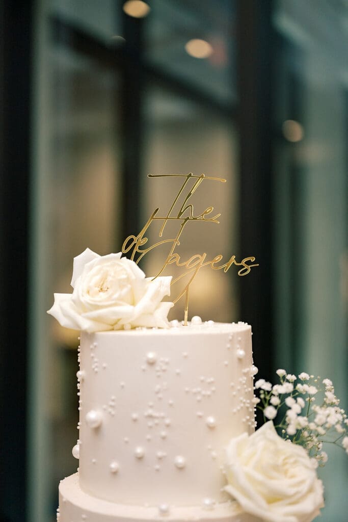 four-tiered white wedding cake on a grand piano at a wedding reception at Hyatt Regency Grand Cypress Resort in Orlando, Florida, captured by Jennifer Holly Photography