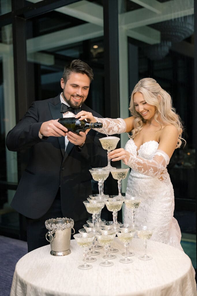 bride and groom pouring a champagne tower at a wedding reception at Hyatt Regency Grand Cypress Resort in Orlando, Florida, captured by Jennifer Holly Photography