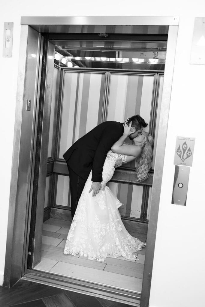 bride and groom kissing in an elevator at a wedding reception at Hyatt Regency Grand Cypress Resort in Orlando, Florida, captured by Jennifer Holly Photography