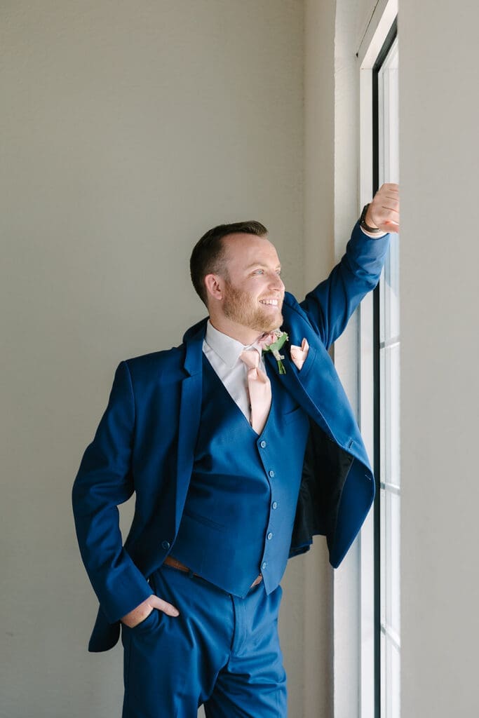 groom in a navy suit with blush tie at Sterling Event Venue in Minneola FL captured by Jennifer Holly Photography
