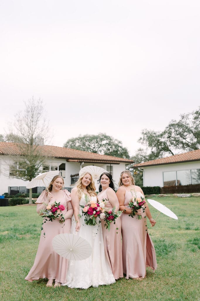 candid wedding party portrait with parasols on the lawn at Sterling Event Venue in Minneola FL captured by Jennifer Holly Photography